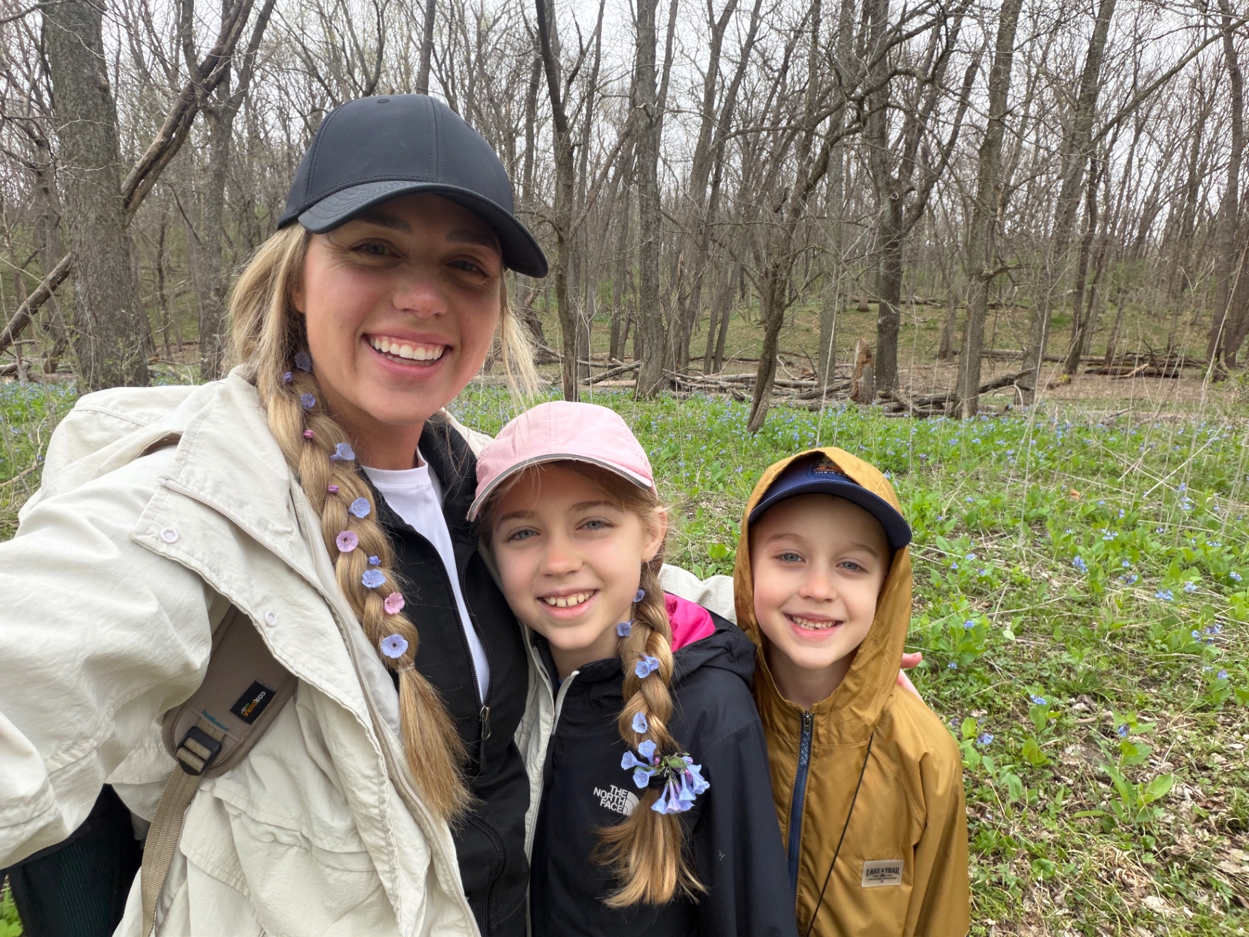 Brittany hiking with Aniston and Noah through a forest of bluebells in spring