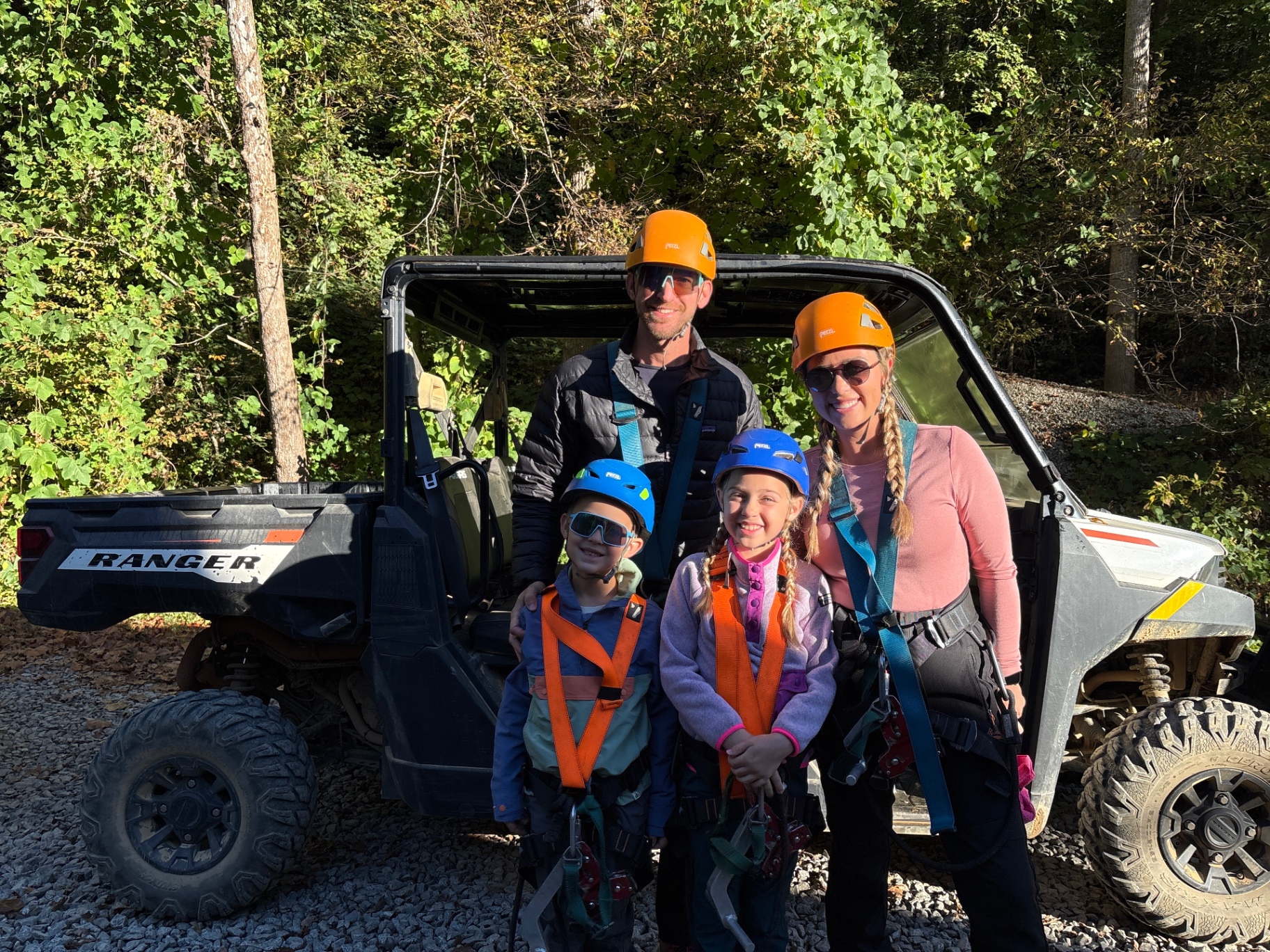 The Venture Seekers family geared up in helmets and harnesses next to the CLIMB Works UTV at the trailhead