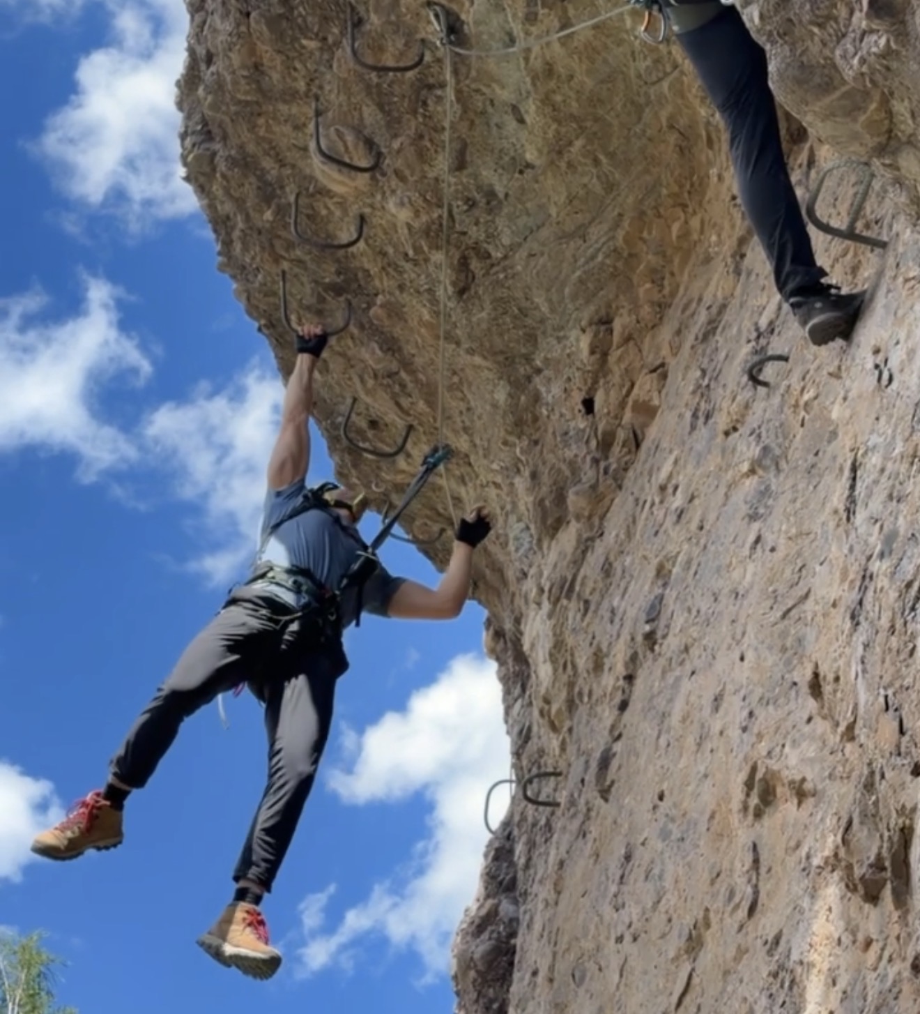 Jake hanging off the overhang on Hardman's Route at the Gold Mountain Via Ferrata