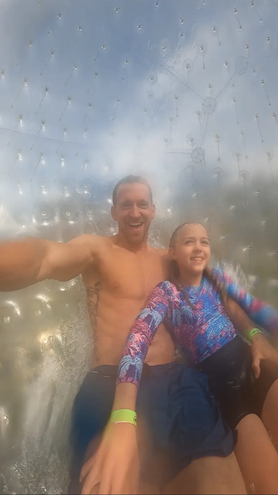 Jake and Aniston sliding through the water inside the zorb ball