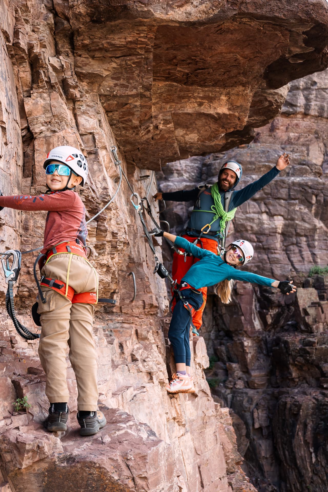 Our family cheering from a ledge under a rock overhang on the Gold Mountain Via Ferrata