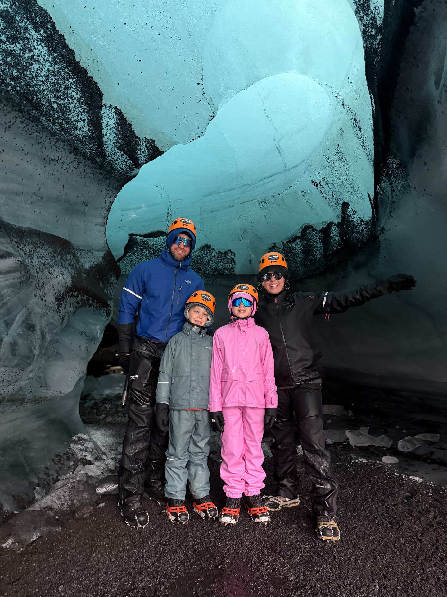All four of us in helmets and crampons inside the blue Katla Ice Cave, our big finish near Vík