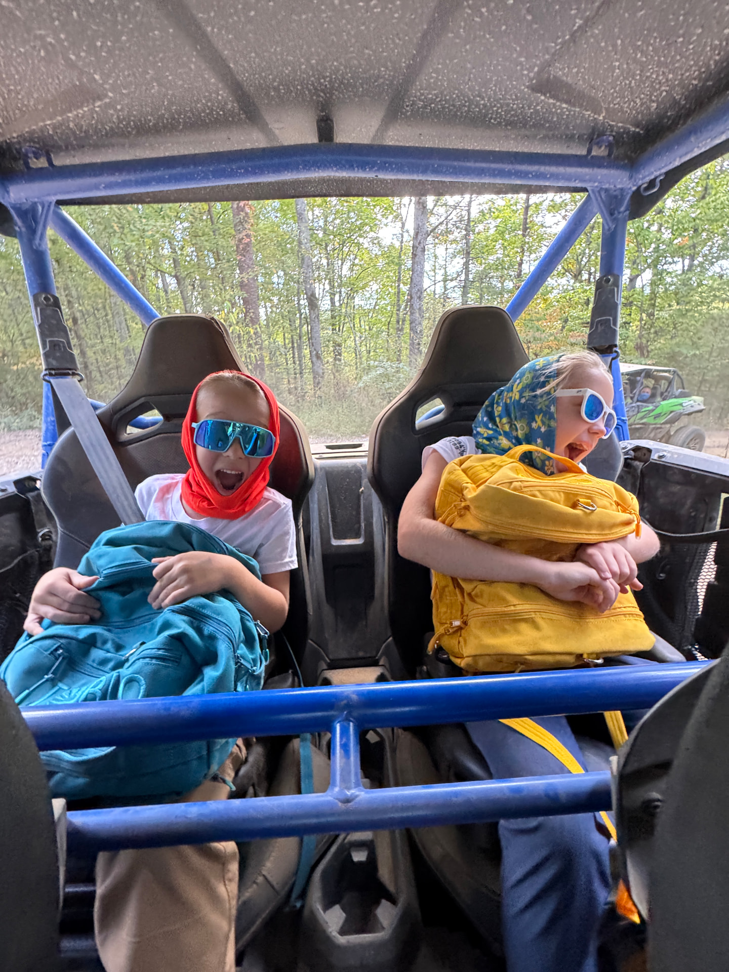 Our kids buckled into the back of the UTV at Off-Road Gatlinburg, laughing in their sun hoods