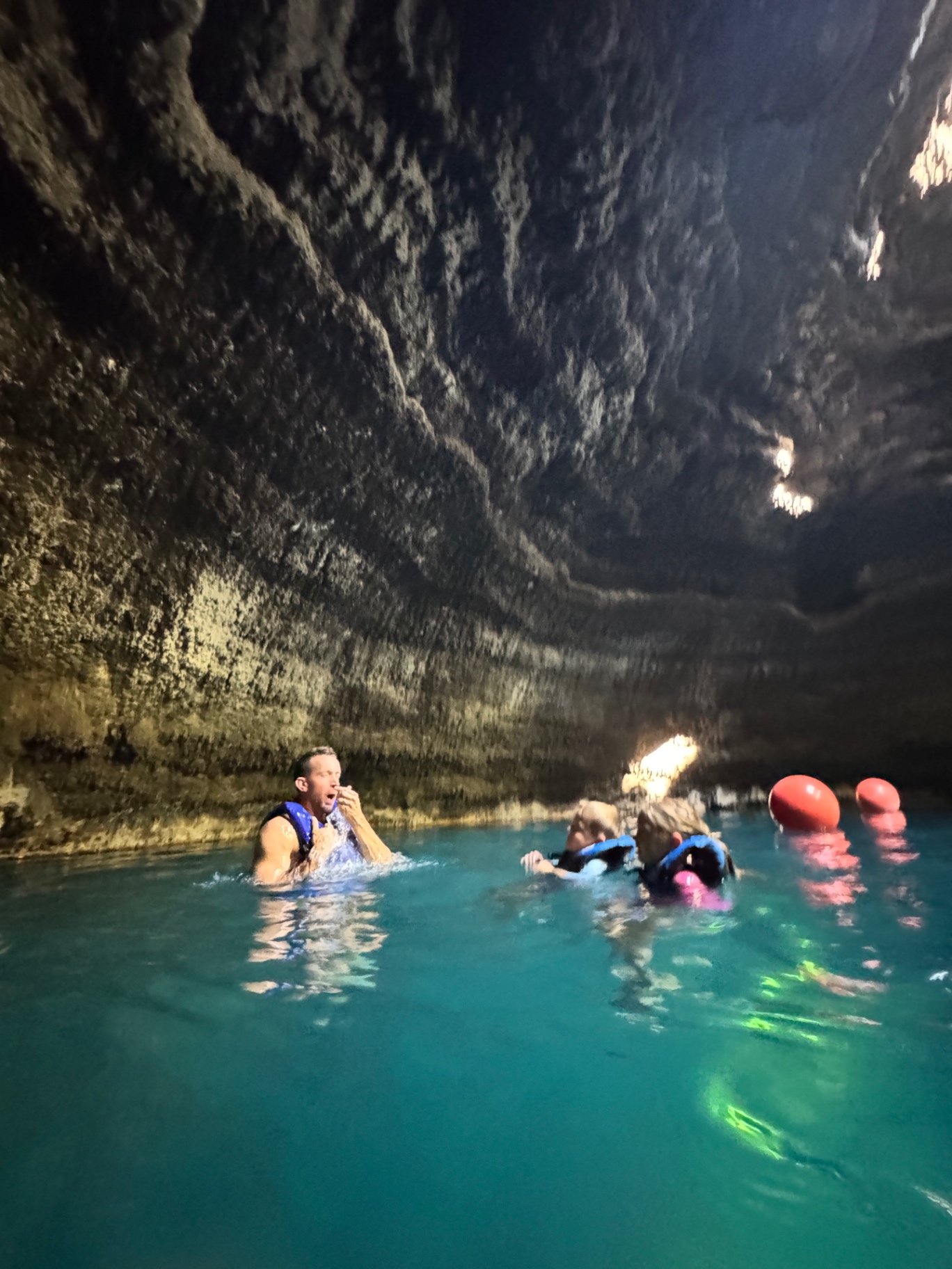 Jake floating in the bright turquoise geothermal water inside the Homestead Crater limestone dome in Midway, Utah