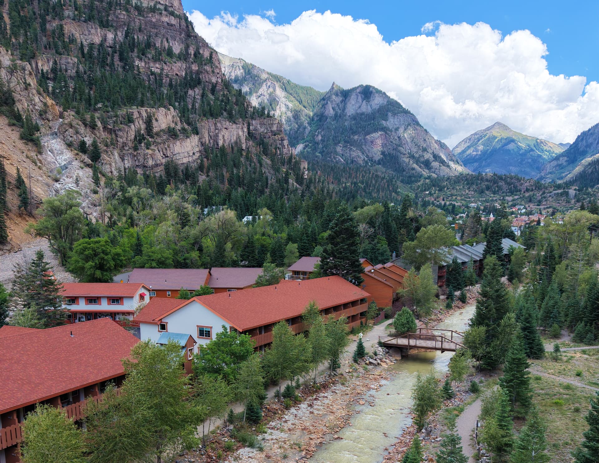 The Hot Springs Inn in Ouray sitting right along the river with the San Juan Mountains behind it