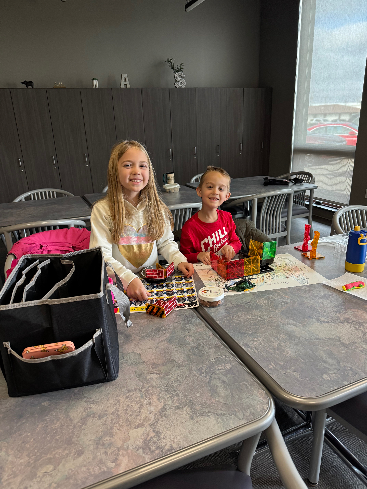 Aniston and Noah doing schoolwork and building with magnatiles at the office while Brittany works as a dental hygienist