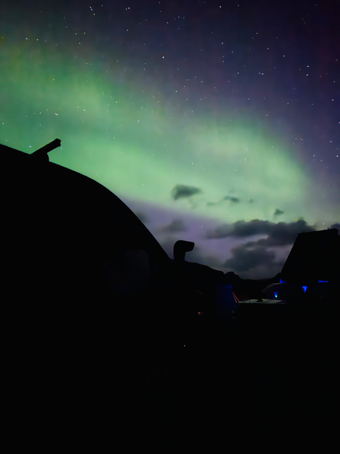 Our first Northern Lights, swirling green above our campervan in Landmannalaugar under a sky full of stars