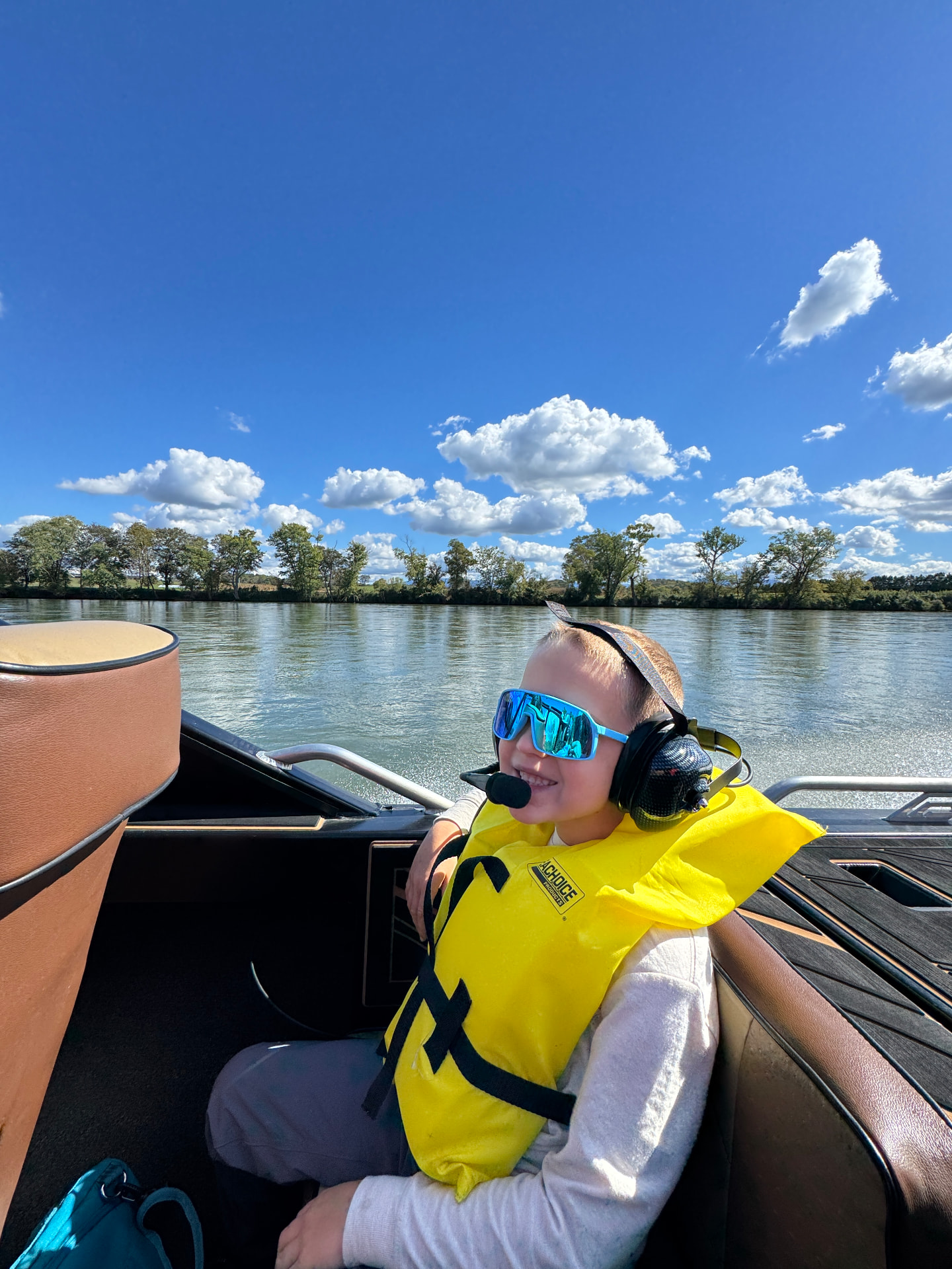 Our son in sunglasses and a headset smiling on the Smoky Mountain Jet Boat