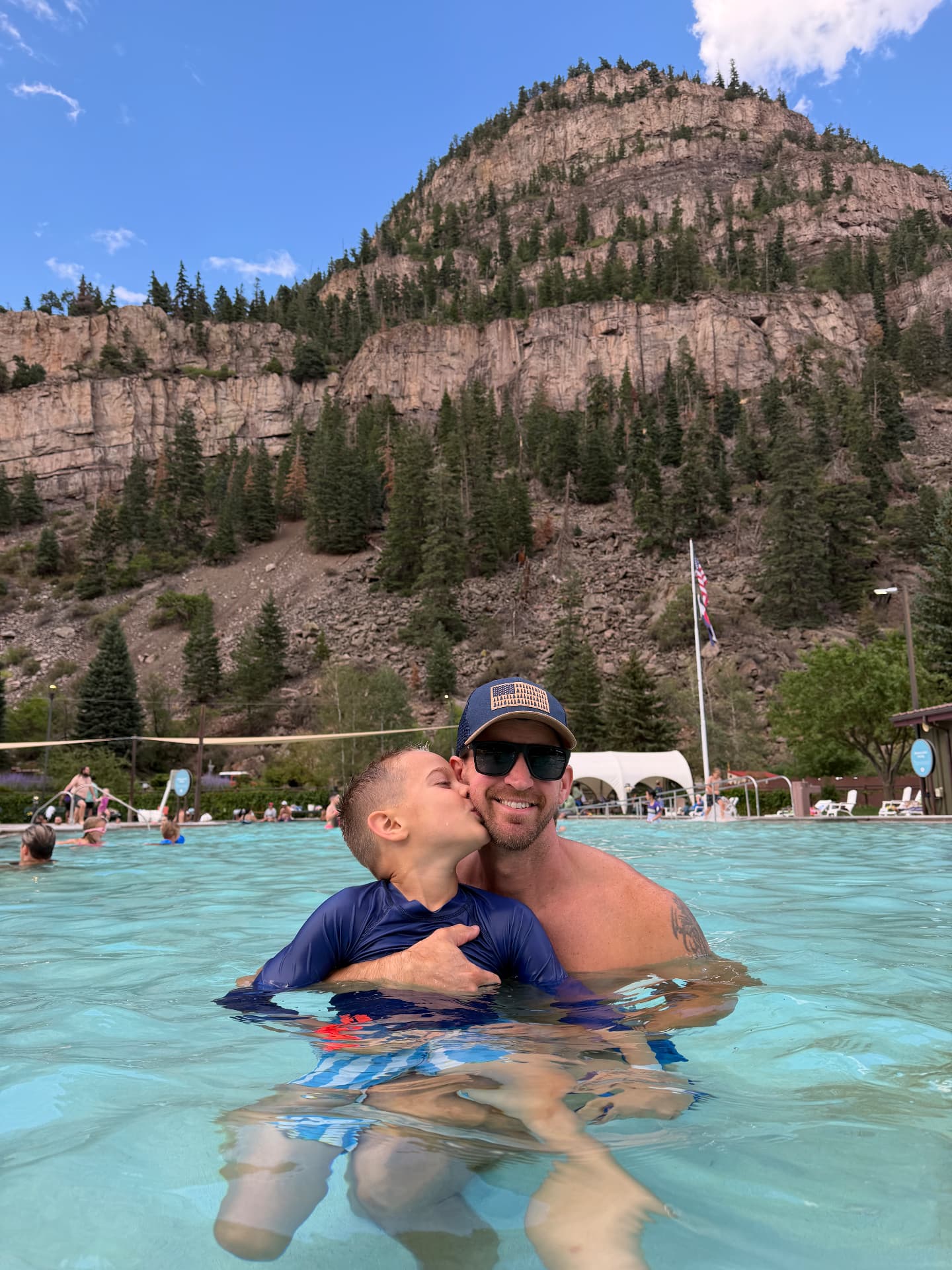 Jake and our son in the Ouray Hot Springs Pool with the cliffs above town behind them