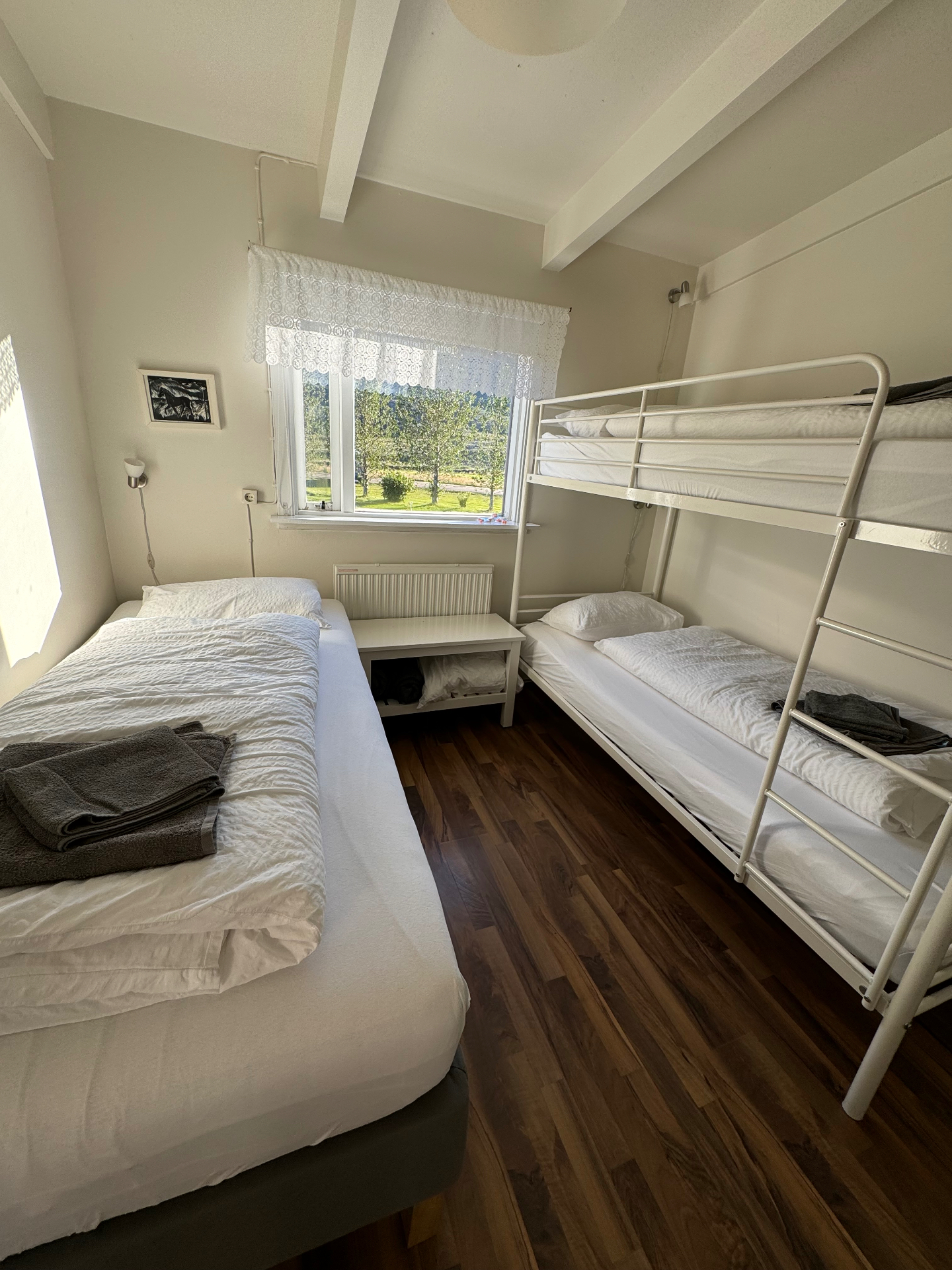The Iceland hostel room with a twin bed and bunk beds