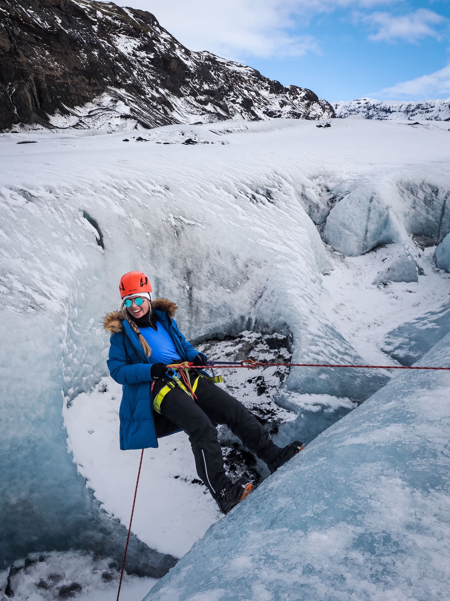 Jake ice climbing a blue glacier wall in Iceland