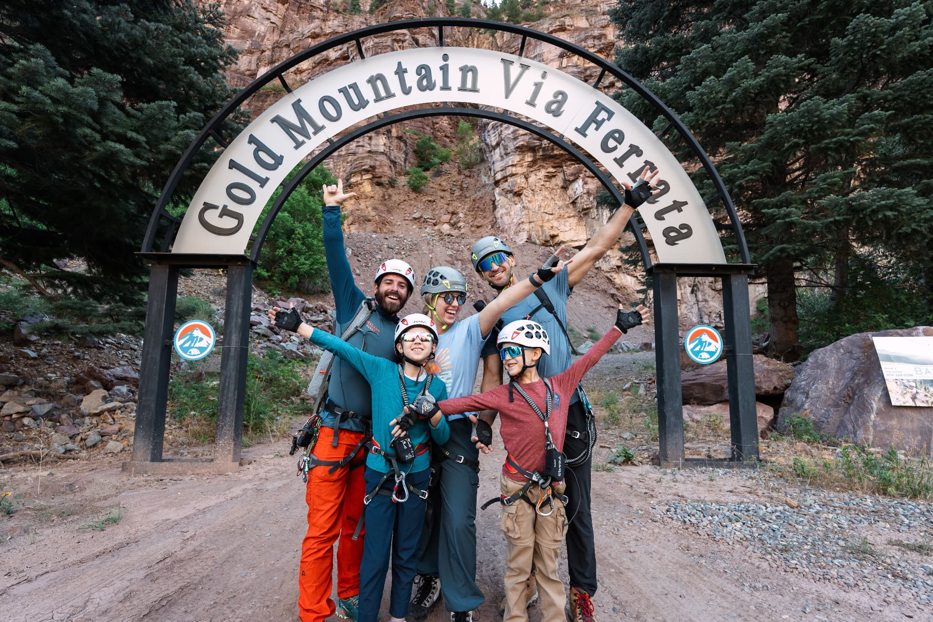 Our family celebrating under the Gold Mountain Via Ferrata arch in Ouray, Colorado