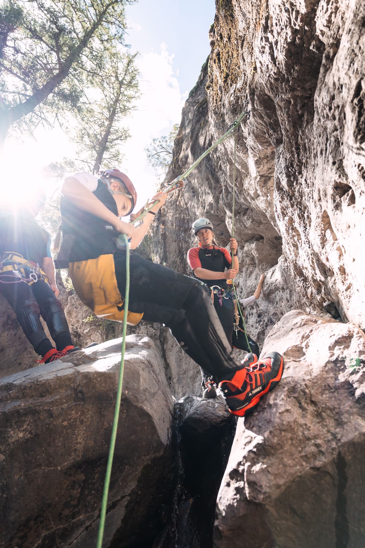 Our daughter rappelling into Portland Creek canyon with a guide managing the rope